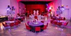 a banquet hall with tables and red chairs