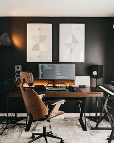 a desk with two monitors, keyboard and speakers on it in front of three pictures