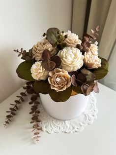 a white vase filled with flowers on top of a table