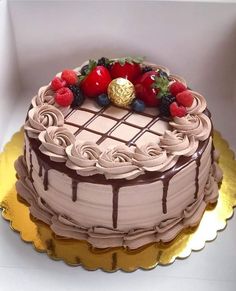 a chocolate cake with strawberries and raspberries on top is in a box