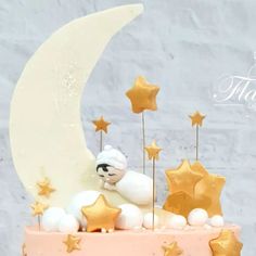 there is a cake decorated with stars and a teddy bear on the moon