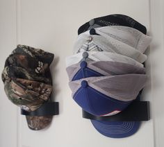 Having trouble with organizing and storing your hats? Taking up too much space on the shelf or laying around?  Stack them vertically on a door or wall in your home! This hat/cap holder works perfectly to store your hats in a way that is easy to access! The hat holder comes with a removeable adhesive Command strip that will stick to any clean flat surface and hold 4-6 hats.  You may also mount it with screws or nails to any surface for additional CAPacity!  Can be used with baseball caps, snapbacks, fitted hats, visors, and flat-brim hats. Baseball Hat Wall Display Bedrooms, Dope Hats Holder, Baseball Hat Wall Display Men, Hat Wall Display Bedrooms Hanging, Hat Wall Display Baseball Cap, Cap Holder, Cap Display, Brim Hats, Flat Brim Hat