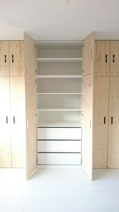 an empty room with wooden cabinets and white flooring