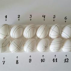 an arrangement of white eggs with black lines on them and numbers in the middle, all lined up