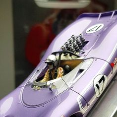 a purple model car on display in a glass case