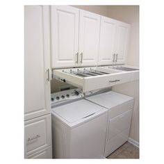 a white washer and dryer in a room with cabinets on either side of the washer