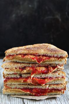 two sandwiches stacked on top of each other with strawberry jam and powdered sugar in the middle