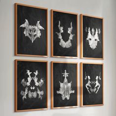 four black and white paintings hanging on the wall