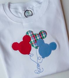 a white shirt with mickey mouse balloons on it