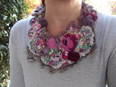 a woman wearing a crocheted necklace with flowers on the front and back,