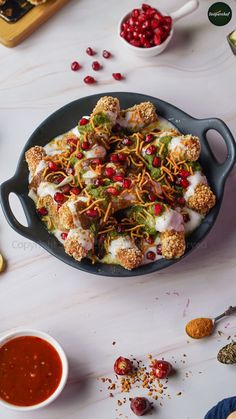 a pan filled with food sitting on top of a table next to sauces and condiments