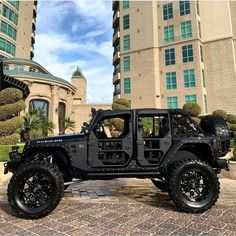 a black jeep parked in front of a tall building