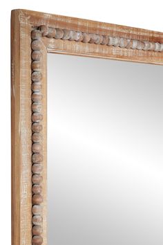 an old wooden frame mirror with beading around the edges