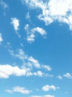 a group of people standing on top of a lush green field under a blue sky