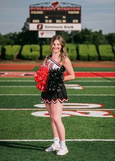 a cheerleader standing on the sidelines at a football game