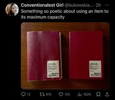 two red notebooks sitting next to each other on top of a wooden table in front of a woman's face