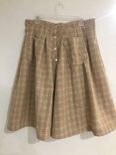 This handmade wool skirt was created with 100% wool material, which makes it perfect for the chilly fall and winter months. It's warm, not too stretchy, falls just below the knee, and holds two pockets. Cottagecore and vintage elements inspire the skirt.  Materials used: Wool fabric, Buttons. Size: Waist 34", Length 27". Vintage Skirt With Pockets, Wool Skirt With Pockets For Work, Fall Flared Skirt With Pockets, Knee-length Bottoms With Buttons For Fall, Knee-length Fall Bottoms With Buttons, Vintage Flared Skirt Bottoms For Fall, Fall Flared Skirt Bottoms With Pockets, Fall Knee-length Bottoms With Buttons, Wool Pleated Skirt Bottoms For Fall