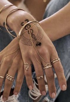 a woman's hands with rings and bracelets on them