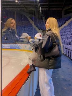 two women standing in front of an ice rink