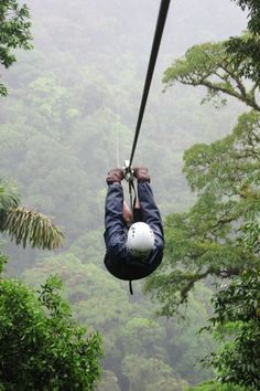 a man is zipping through the trees on a rope