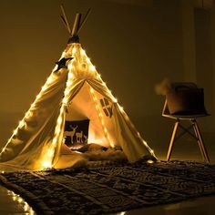 a teepee is lit up with fairy lights