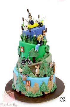 a three tiered cake decorated with people riding bikes and camping signs on the top