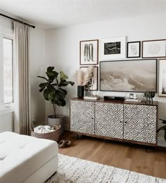 a living room filled with furniture and pictures on the wall next to a large window