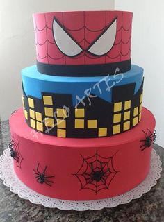 a three tiered cake with spiderman decorations on it