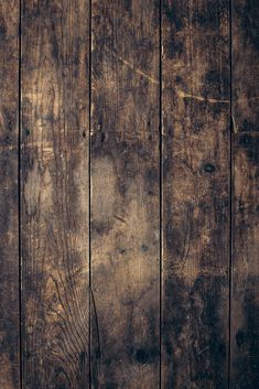 an old wooden wall with peeling paint on the top and bottom part, showing woodgrains