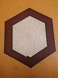 the floor is made up of hexagonal tiles with brown and white designs on them