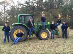 a group of people standing in front of a tractor