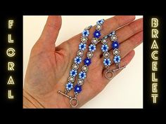 a hand holding three bracelets with blue beads