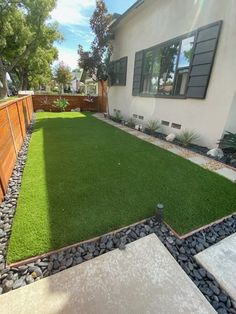 a backyard with artificial grass and landscaping