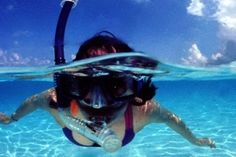 a woman swimming in the ocean with her snorkel