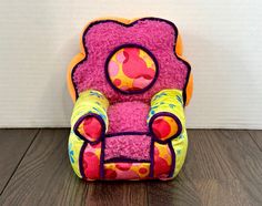 a pink and yellow chair sitting on top of a wooden floor