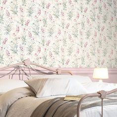 a bed with white sheets and pillows in front of a wallpapered headboard