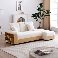 a living room with a white couch and coffee table in front of a large window