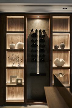 an open bookcase with vases and other items on display in front of it