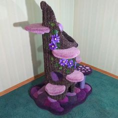 a cat house made out of felt with flowers on it