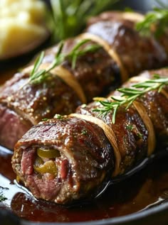 meat wrapped in vegetables on a plate with sauce and garnishes around it