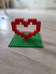 a lego heart sitting on top of a wooden table