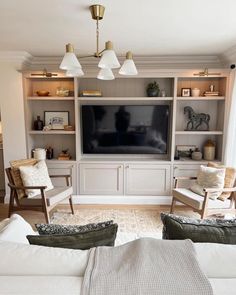 a living room filled with furniture and a flat screen tv on top of a wooden entertainment center