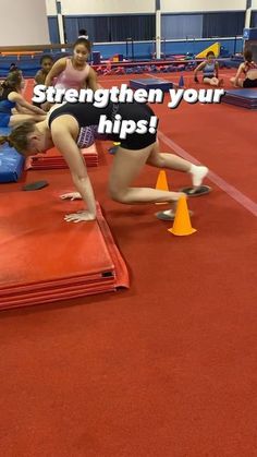 some girls are doing tricks on the floor in an indoor track and field area, with text overlay that reads, strength your hips