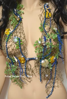 a female mannequin wearing a piece of clothing with beads and leaves on it