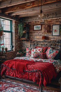 a bed in a room with brick walls and red bedspread on top of it