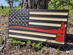 an american flag made out of wood with a hammer sticking out of the center on top