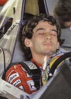 a man with his head resting on the back of a race car driver's seat