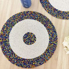 two placemats with different colored beads on them