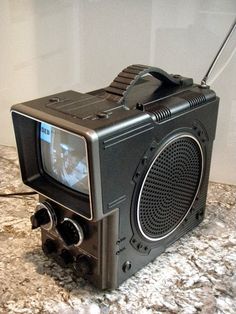 an old fashioned radio sitting on top of a granite counter next to a white wall