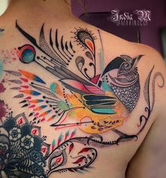 a colorful tattoo on the back of a woman's upper body, with birds and flowers